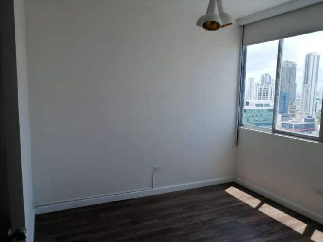 Empty bedroom with large window, wood flooring city view in PH Famagosta Loft Panama City