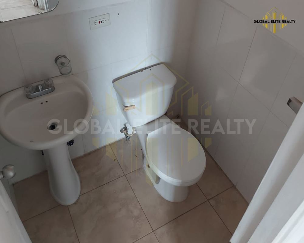 Compact bathroom with pedestal sink, mirror, tiled walls in Villa Lucre apartment Panama