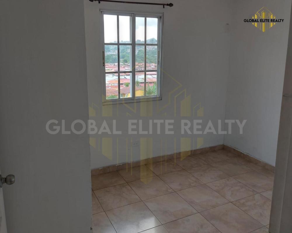 Bedroom overlooking hillside and city with bright window in Villa Lucre apartment Panama