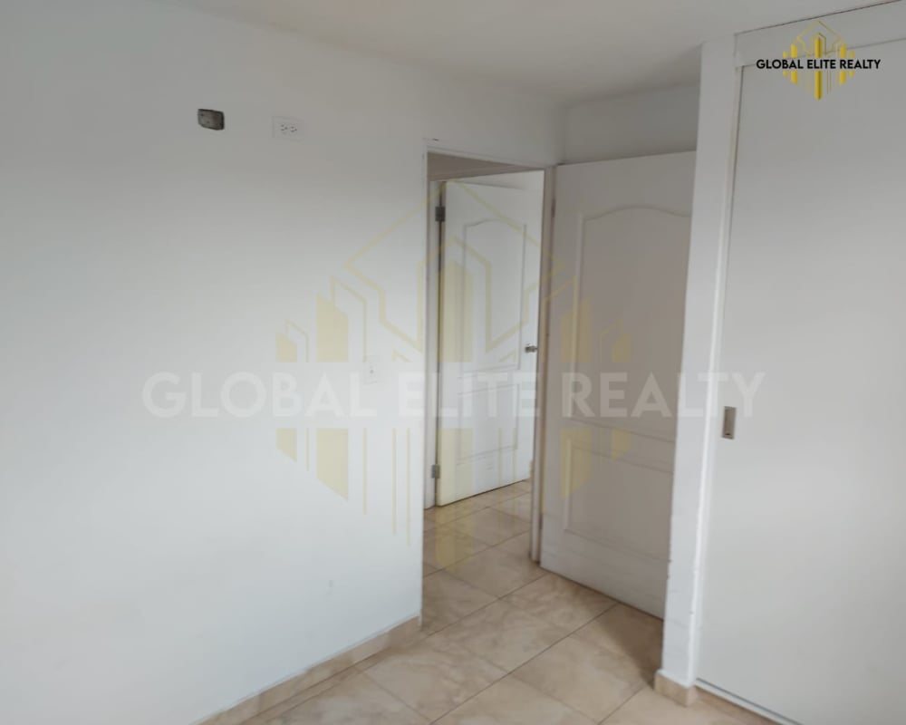 Bedroom with sliding closet doors and tile floors at Villa Lucre Condominium Panama