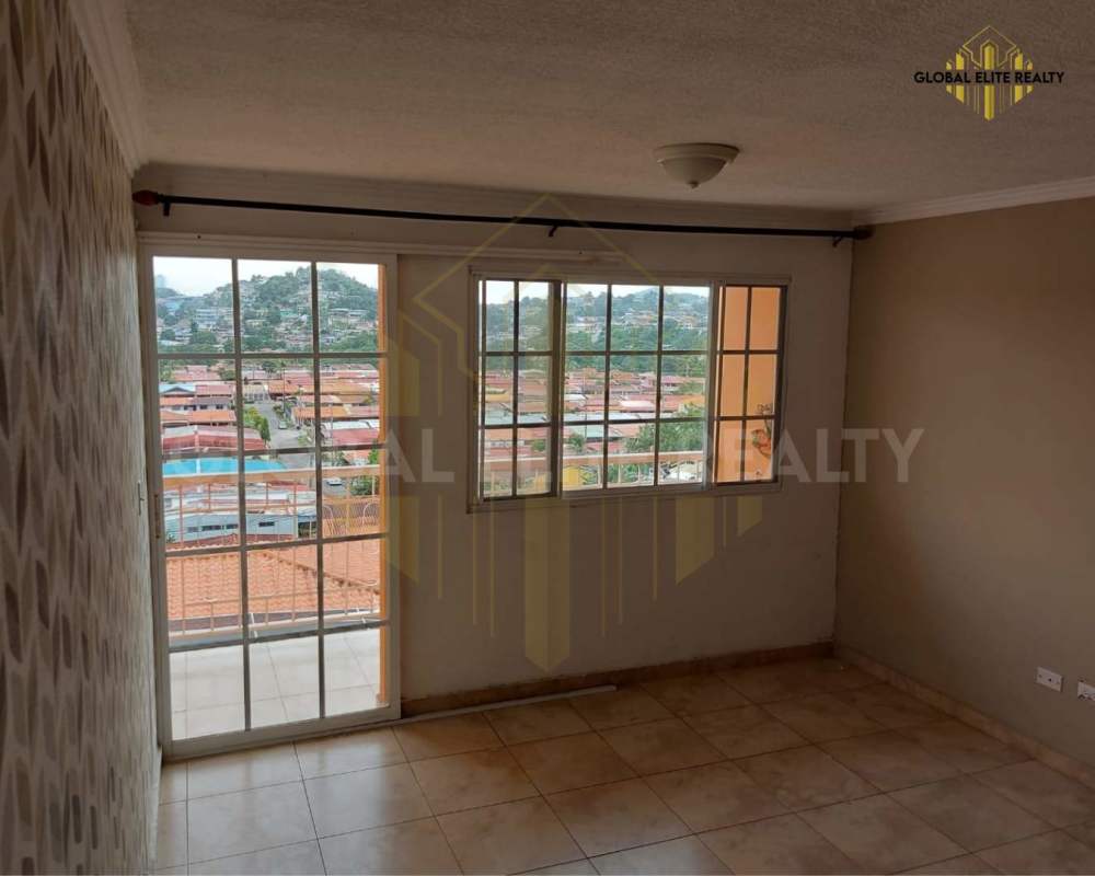 Spacious living room with sliding doors, view of city and hills, Villa Lucre condo Panama