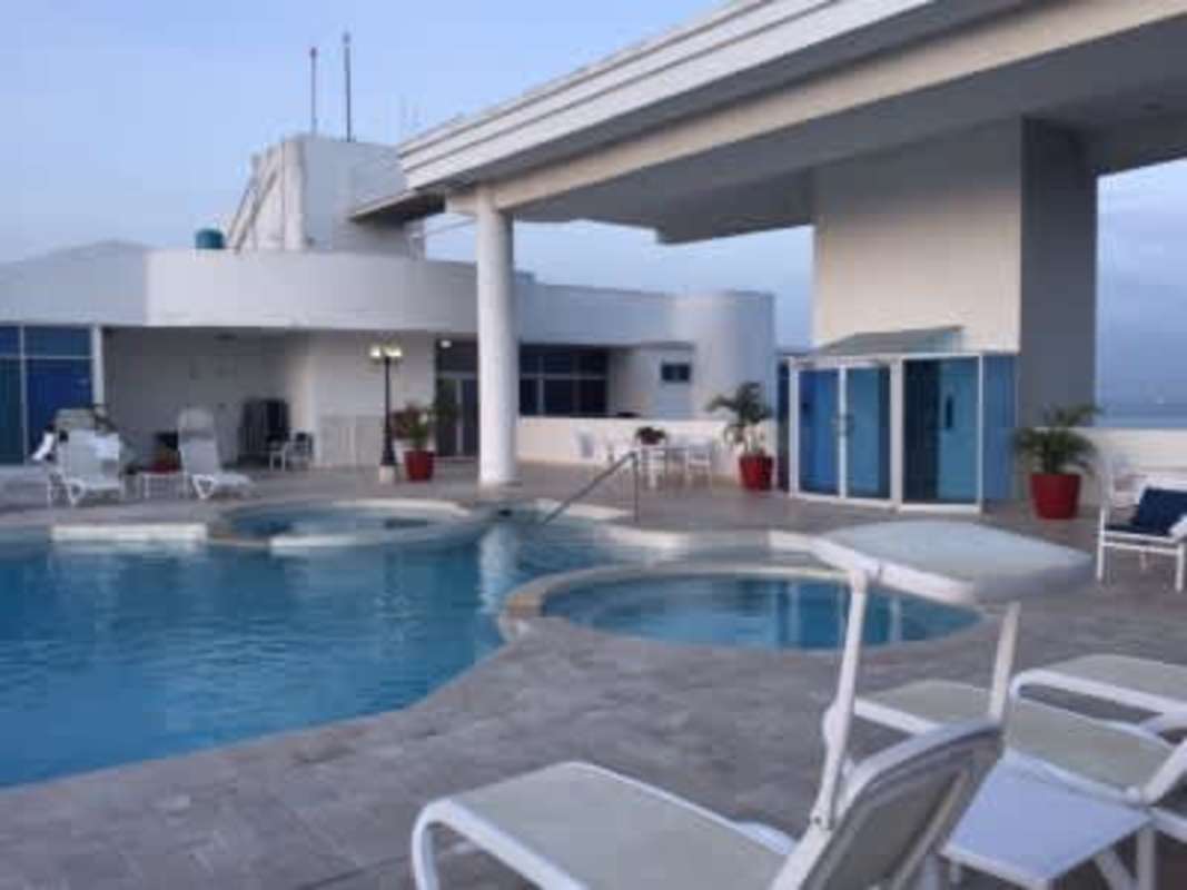 Spacious kitchen with granite countertops, dark cabinets and stainless appliances in PH The Bridge Ancón