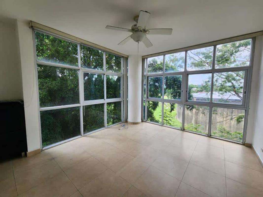 Private balcony with glass railings overlooking lush greenery PH The Bridge Ancón Panama