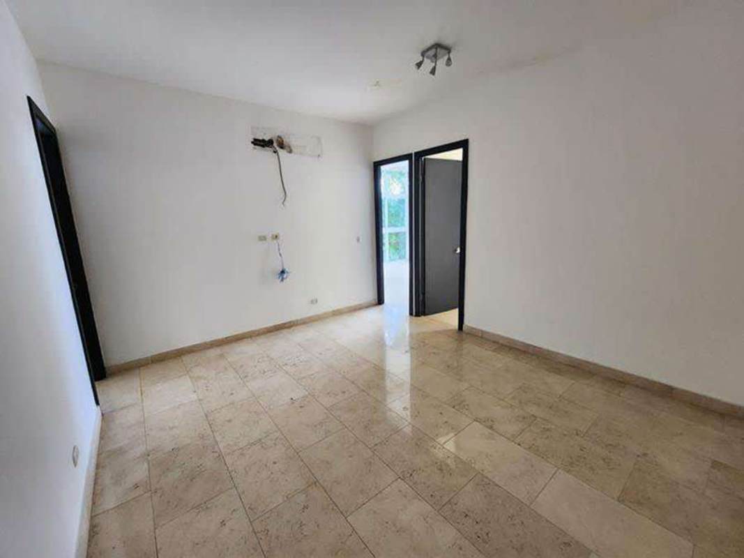 Spacious bedroom suite with tile floors, built-in closet, and panoramic windows PH The Bridge Ancón