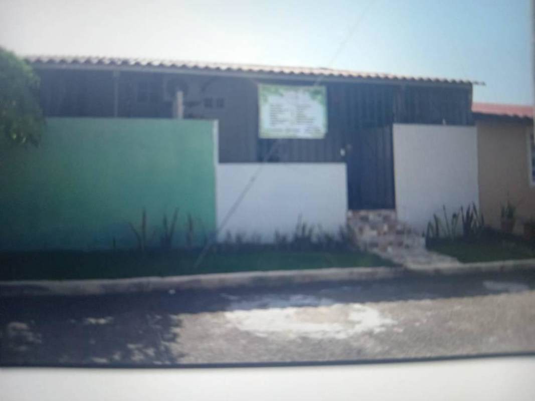 Traditional green painted house front with porch and driveway in Las Mañanitas, Panama City
