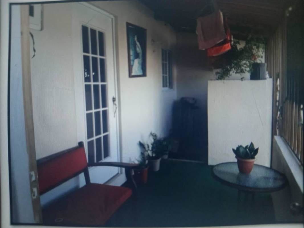 Balcony patio with glass door, plants and seating in residential house Las Mañanitas, Panama