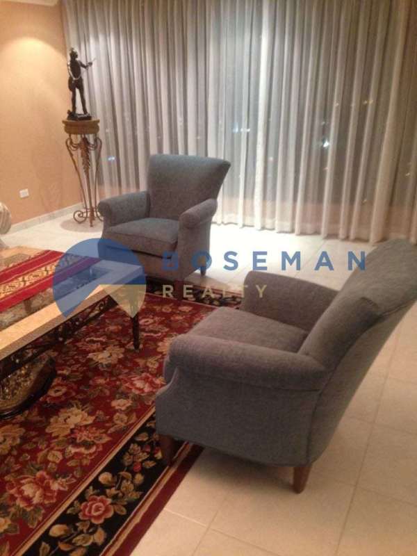 Living room with grey armchairs, large curtains, city view at PH La Fontana Obarrio Panama City