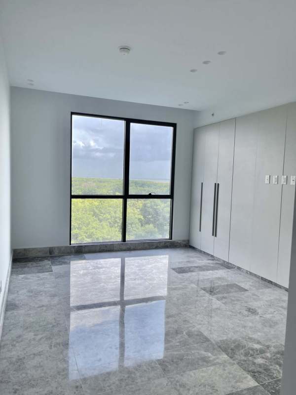 Minimalist large bedroom with floor-to-ceiling window and golf course panoramic view PH Oceana Santa María Panama City
