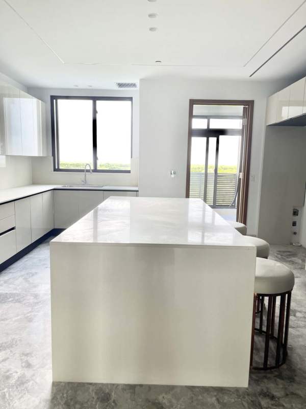 Sleek kitchen with glossy cabinets, marble countertop island and large windows at PH Oceana Residences Santa María Panama