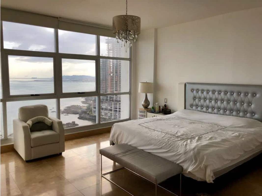 Large bedroom with panoramic windows overlooking ocean and city PH Q Tower Panama