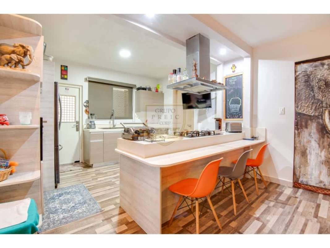 Modern living and dining area with wood accents, green wall, elephant art at PH Victoria Paseo del Norte Panama