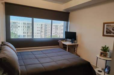 Stylish bathroom with glass enclosure and tile walls in Midrise Panama Pacifico apartment