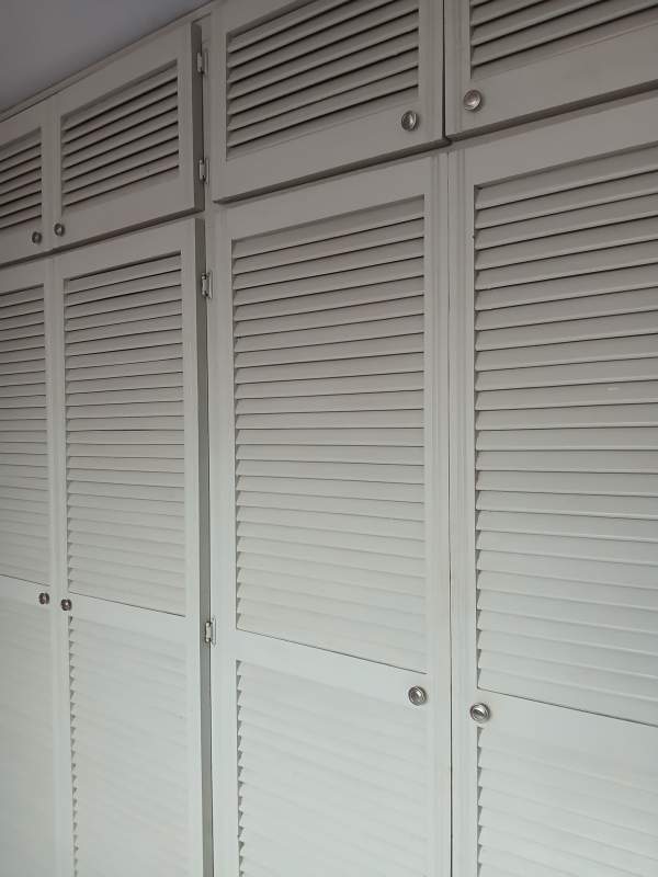 Built-in wardrobe with louvered doors off white panels in bedroom Condado del Rey Panama