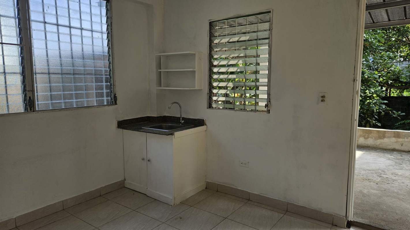 Open plan kitchen with granite countertop and outdoor access window in Las Cumbres Panama apartment for rent