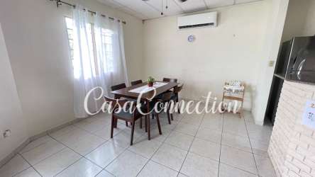 Dining area with tile floor, AC unit, and window in furnished house David Panama