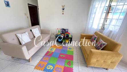 Bright living room with tiled floor, sofas, play area and large window in La Fontana David Panama