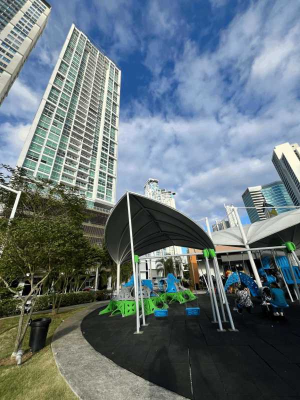 Modern tower view with playground and shaded parks at PH Asia Costa del Este Panama