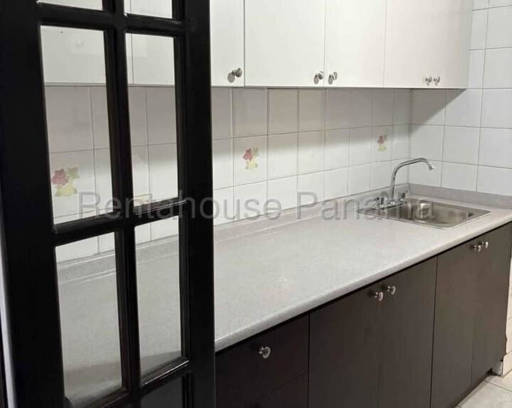 Kitchen space with white cabinets, stainless sink, floral tile accent PH Plaza Dos Mares Panama