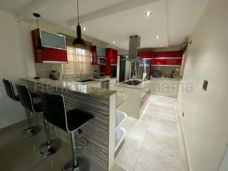 Bright open plan living dining area with tile floors, chandelier and double glass doors in La Chorrera house