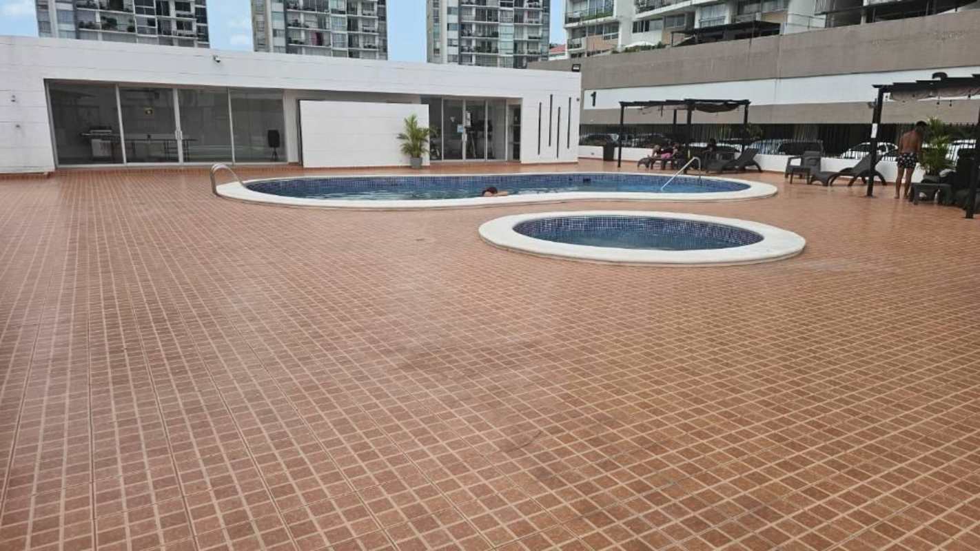 Swimming pool shared by residents at PH Torre Alsacia with sun terrace and seating