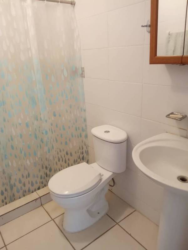 Compact bathroom with shower pedestal sink white tiles Villa Lucre Panama apartment