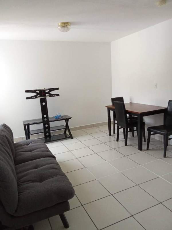 Open-plan living and dining area with sofa dining table TV stand in Villa Lucre Panama rental