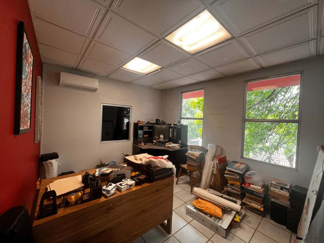 Modern open office workspace with accent wall, open staircase and workstations in commercial property Llano Bonito Panama