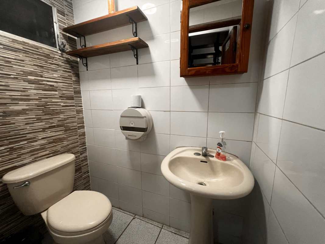 Compact bathroom with tiled walls, mirror and fixtures in Llano Bonito commercial rental