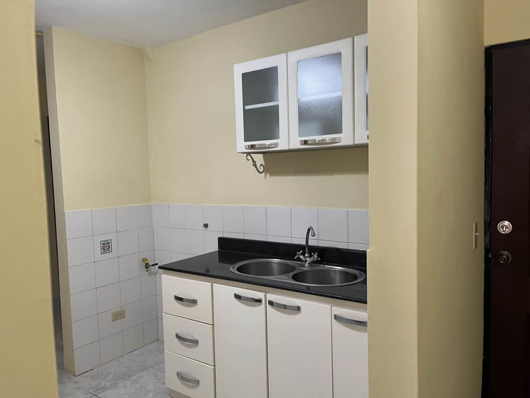 Kitchen with arch window tiled walls white cabinets Betania Apartment Panama