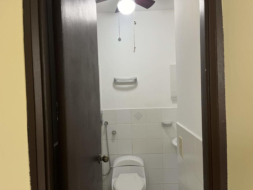 Compact bathroom fully tiled with ceiling fan and bidet spray Betania Panama Real Estate