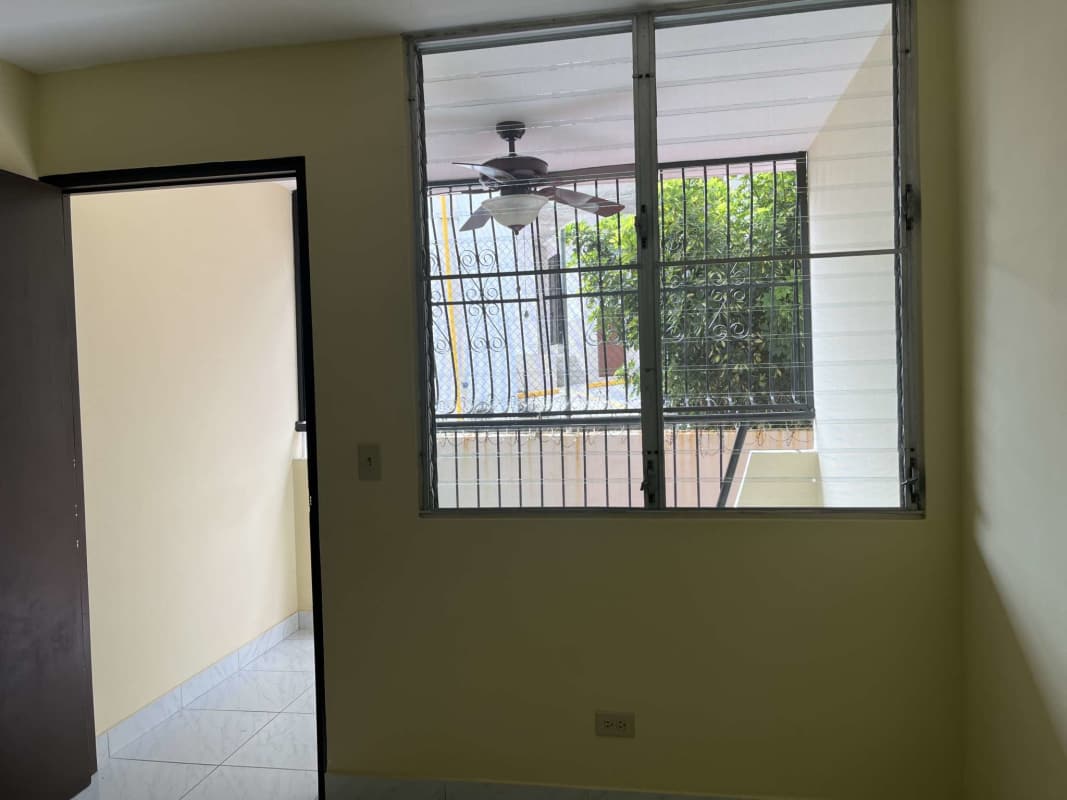 Bedroom with large window, ceiling fan and view to patio Betania apartment for sale Panama City