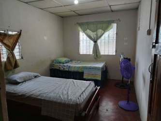 Simple kitchen space with upper cabinets, microwave and portable stove in student rental Veraguas Panama