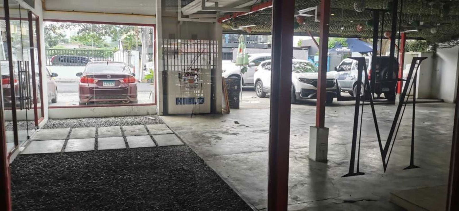 Commercial area with large windows cement floor parking and signage commercial building Panama