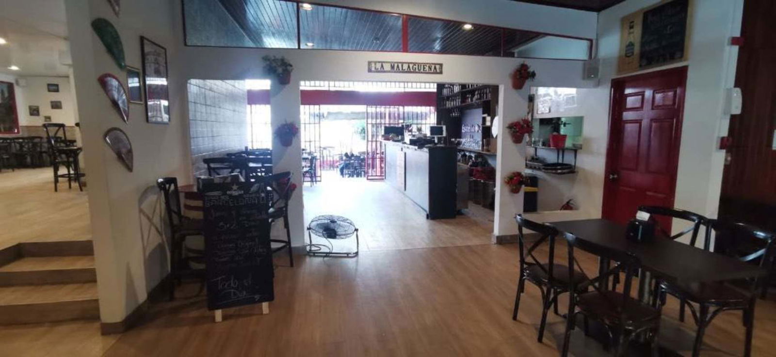 Interior dining and service area of restaurant with wood flooring decorative fans and counter