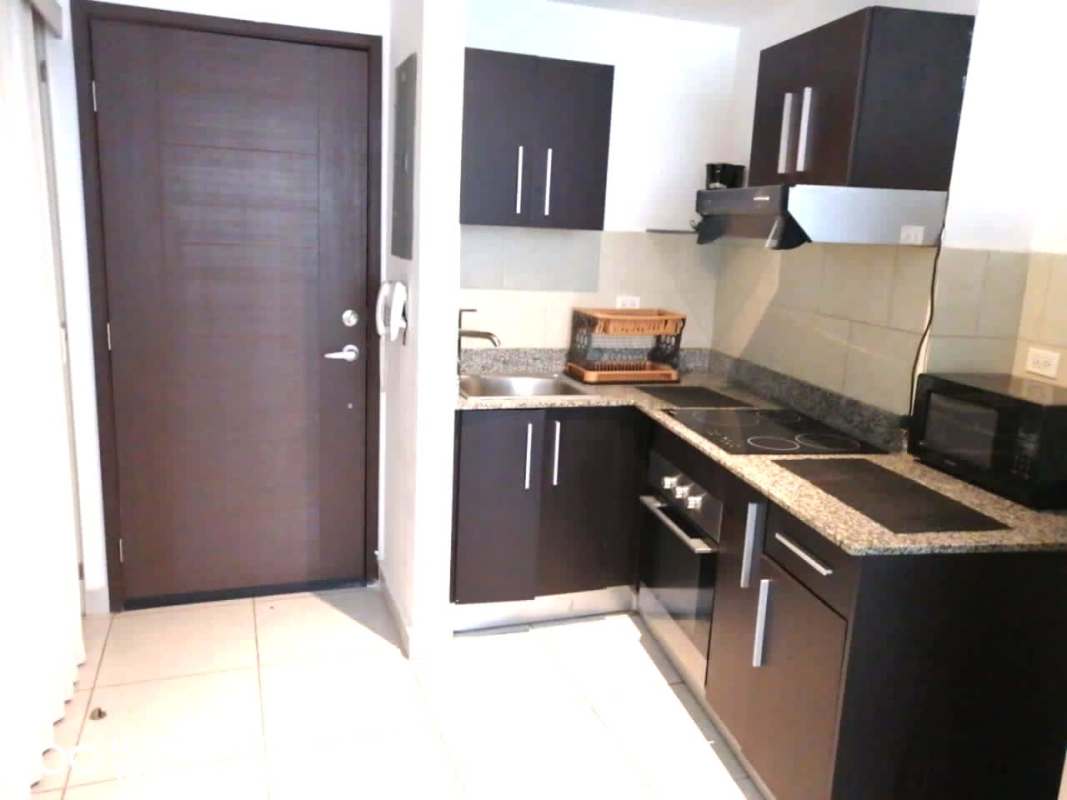 Living-dining room with blue sofa, flat screen TV and large windows PH Miramar Panama