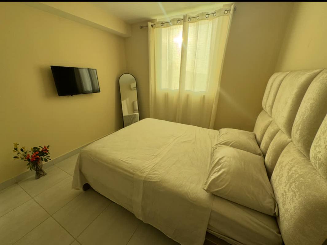 Bedroom with padded headboard, large window, built-in closet, flat-screen TV at PH Carrasquilla Tower Panama