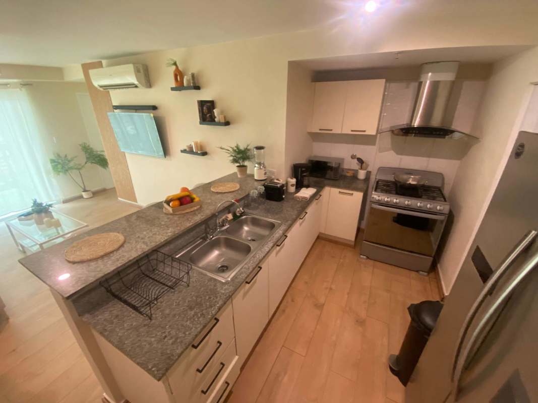 Kitchen with granite countertop, stainless appliances, breakfast bar at PH Carrasquilla Tower Panama