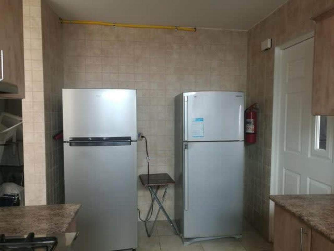 Kitchen area with wooden cabinetry, stove, and granite style finishes PH Porto Fino San Francisco