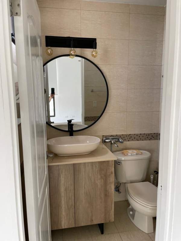 Contemporary bathroom with beige tiles, vessel sink, round mirror and shower in PH San Francisco Bay Tower 300 Panama