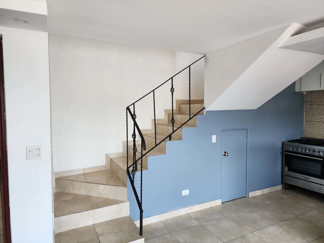 Kitchen area with stairway, wrought iron railing, tile flooring in duplex apartment PH Torres del Crisol II El Crisol Panama