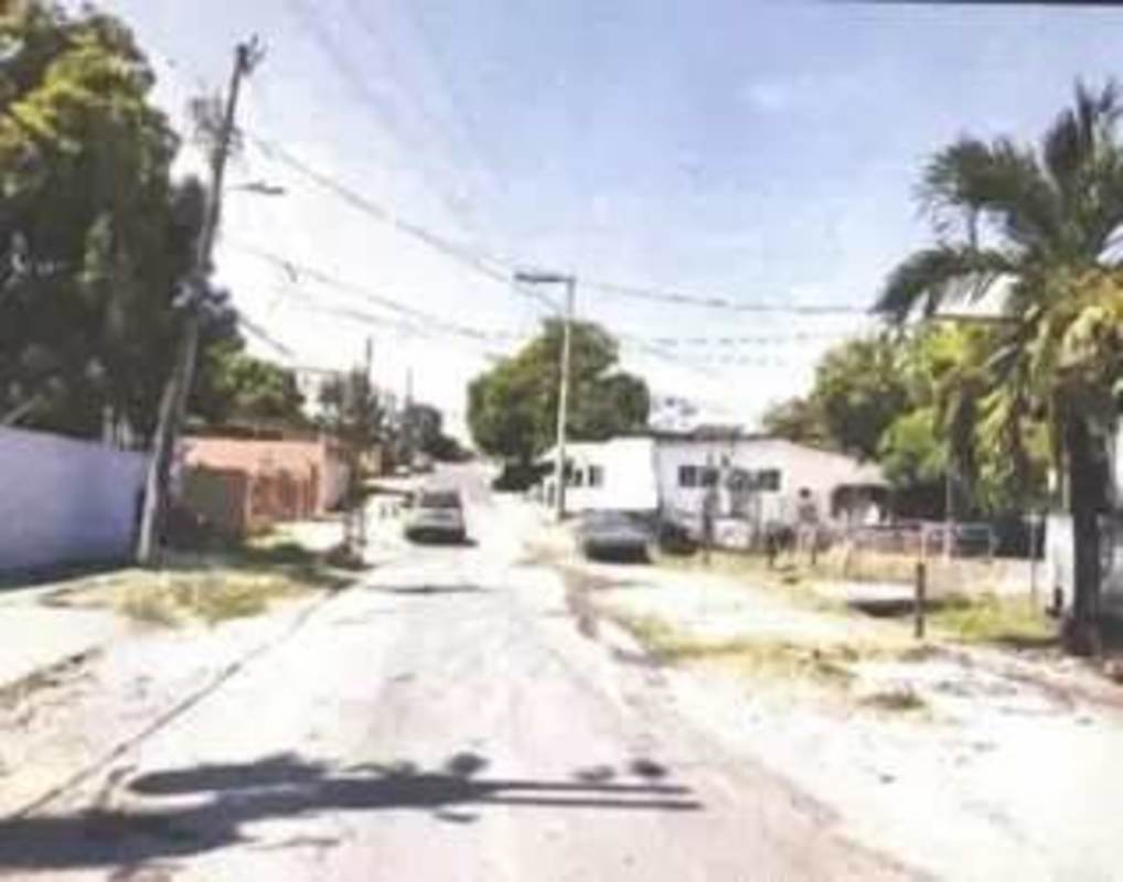 Residential street with utility wires and sidewalk near warehouse Rio Abajo Panama City