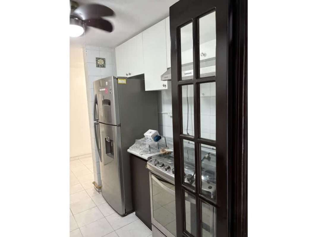 Kitchen with white cabinets, stainless appliances, marble counters, glass door