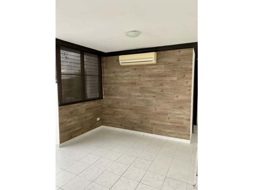 Bedroom featuring wood accent wall, split AC, window and tiled flooring