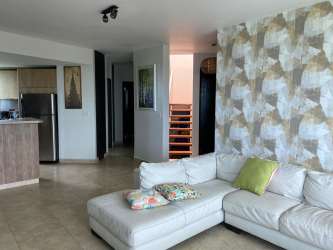 Bright living dining room open layout glass doors balcony Playa Blanca Panama penthouse