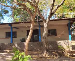 Tropical yard with porch shaded by trees rustic beach house Panama