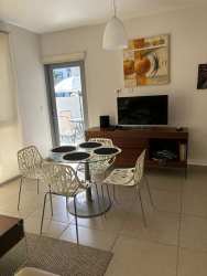 Modern living dining area with round table, wall art and TV console in PH Mosaic Panama
