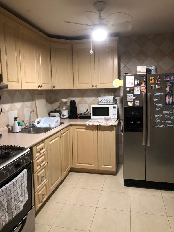 Kitchen with granite countertops, wooden cabinets and appliances in Condado del Rey house Panama