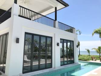 Modern living area with marble floors and floor-to-ceiling glass doors opening to terrace with ocean view in luxury villa Buenaventura