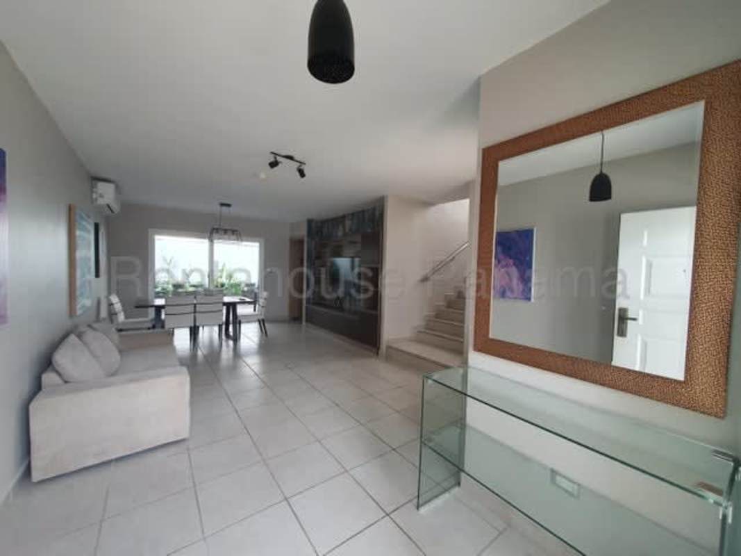 Bright open concept living dining room with tiled floors staircase in townhouse Brisas del Golf Panama