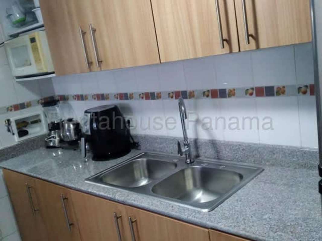 Kitchen with granite counters, white cabinets at PH Prisma apartment Parque Lefevre Panama for sale